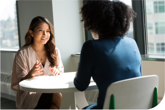Deux femmes en train de discuter autour d'une table